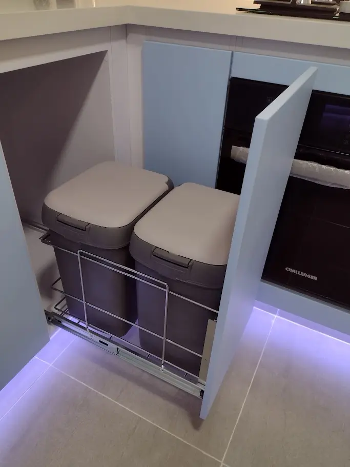 Sistema de basureras extraíbles ocultas dentro de los gabinetes de una cocina integral moderna