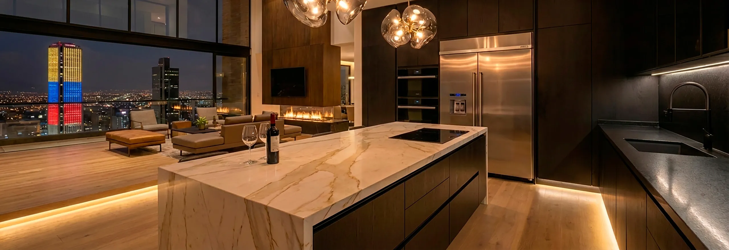 Espectacular cocina de lujo en penthouse con gran isla de mármol y vista nocturna a la Torre Colpatria en Bogotá, diseñada para disfrutar de momentos exclusivos.
